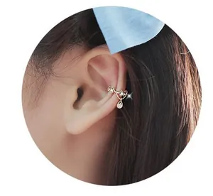 Detalle de un ear cuff floral dorado con circonitas en forma de gota de agua