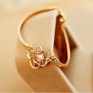 Elegant gold hollow rose crystal bracelet featuring a central amber gemstone on a display stand