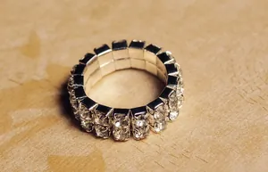 Macro detail of silver stretch ring with double row of shiny white rhinestones