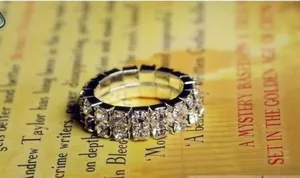 Macro shot of double-row sparkling rhinestone elastic ring on vintage paper background