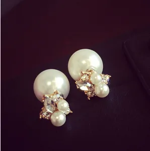 Detailed macro view of gold-plated double-sided pearl earrings with marquise rhinestones