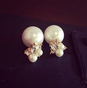 Close-up of elegant double-sided pearl earrings with crystal details on black leather