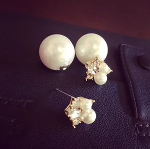 Detail of double-sided pearl earrings with crystals on luxury purple leather backdrop