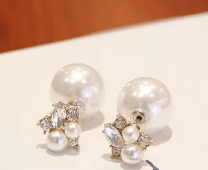 Macro side view of double-sided pearl earrings with clear rhinestones and golden base