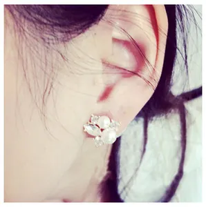 Close-up of elegant double-sided pearl earrings with marquise rhinestones worn on ear