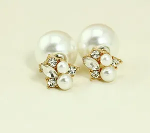 Close-up of double-sided gold pearl earrings with sparkling rhinestones and marquise crystal