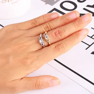 Close-up of gold and silver skull rings with round cubic zirconia on a hand