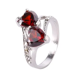 Detail shot of double red heart-shaped crystals on a silver ring with pavé side stones