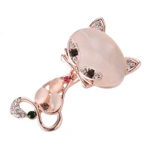 Élégante broche chat en or rose avec pierres d'opale rose et accents de strass brillants