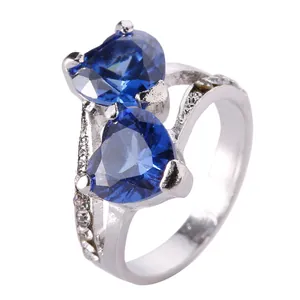 Macro view of blue heart-shaped double gemstones and silver ring band details