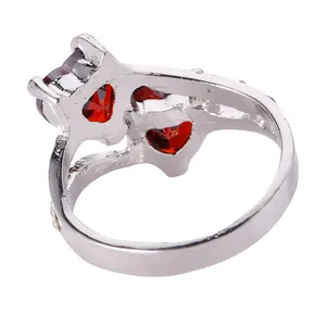 Silver fashion ring featuring three red heart crystals and small diamond accents on white