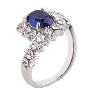 Detailed view of an oval blue gemstone ring with a halo of white rhinestones