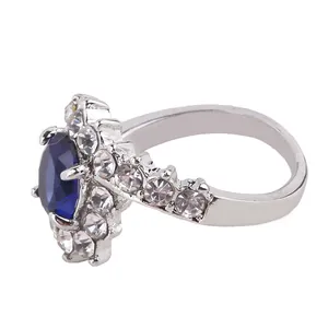 Detailed side view of silver ring with large oval blue gemstone and diamond halo inlay