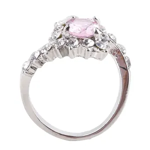 Macro detail of oval pink zircon ring with pavé diamond setting on silver band