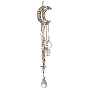 Detalle del clip de luna con borlas, pedrería, estrellas y colgantes de cristal