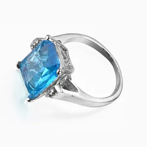 Elegant silver ring featuring a square blue crystal and side diamond accents on white background