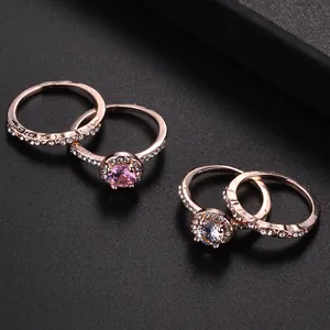 Two-piece rose gold bridal set with pink and white round halo crystals on a matte surface