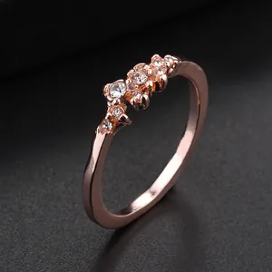 Anello in oro rosa con nove cristalli luccicanti incastonati in un grappolo irregolare