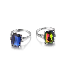 Close-up of square cut crystals in blue and iridescent colors with silver claw setting