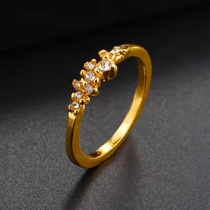 Elegante anello in lega dorata con nove cristalli trasparenti su una fascia lucida