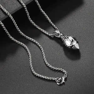 Gros plan du pendentif football américain en argent avec texture de couture réaliste