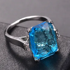 Luxurious silver ring featuring a large emerald-cut blue crystal and pavé side stones
