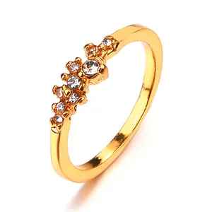 Dettaglio dell'anello dorato con grappolo di strass trasparenti e design in cristallo