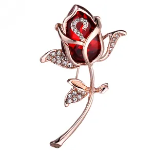 Broche de oro rosa con flor de cristal rojo y hojas con diamantes brillantes