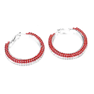 Macro shot of silver hoop earrings featuring three rows of vibrant red rhinestones