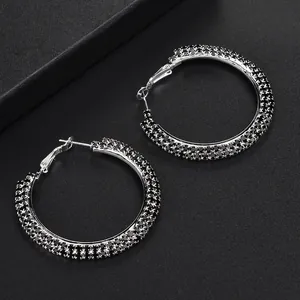 Silver hoop earrings featuring three rows of black rhinestones in a large circular design