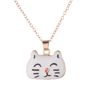 Détail d'un pendentif chat en émail blanc minimaliste avec une chaîne dorée