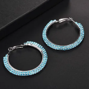 Sparkling silver hoop earrings with triple rows of light blue rhinestones on black