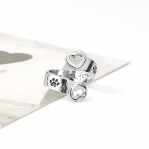 Detail of silver heart ring showing paw prints and 'you forever' engraving