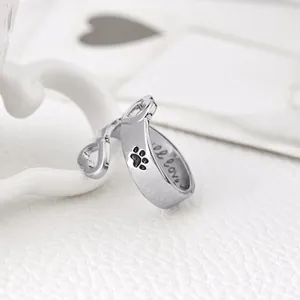 Macro shot of silver ring with black paw prints and I love engraving detail