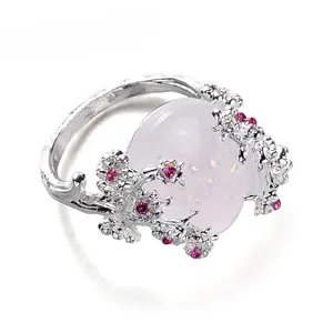 Silver twig ring with large oval opal and pink floral gemstones on white background