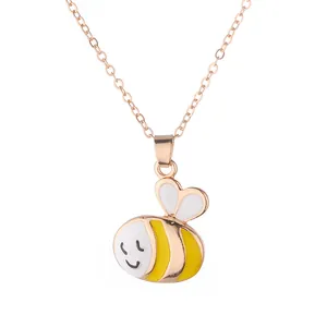 Gros plan détaillé du pendentif abeille avec émail jaune et fine chaîne à maillons dorés