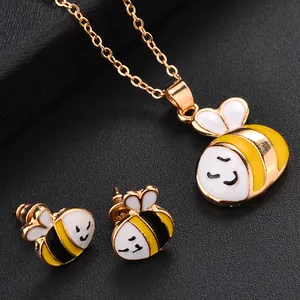 Vue macro d'un ensemble de bijoux abeille dorés avec pendentif et boucles d'oreilles émaillés