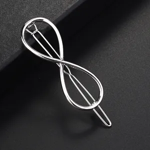 Detalle de pinza para el pelo plateada con forma de infinito en acabado metálico