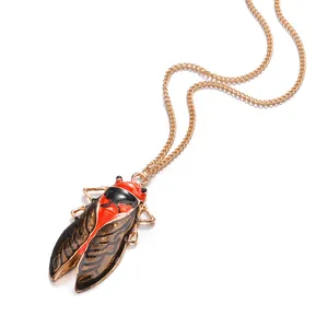 Detail view of a vintage-style cicada pendant necklace with red and black enamel wings