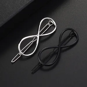 Detalle de pinzas para el cabello infinitas de metal plateado y negro con textura