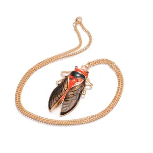 Macro shot of vintage cicada pendant with orange enamel detail on fine gold chain