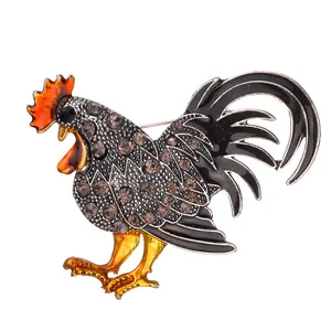 Broche de gallo con pedrería brillante, cresta de esmalte rojo y base de metal plateado
