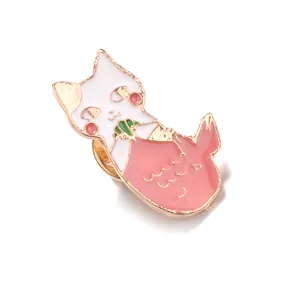 Dettaglio della spilla a gatto in smalto rosa e bianco con bordi metallici dorati
