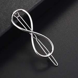 Pinza para el pelo con forma de infinito en metal plateado sobre fondo negro fino