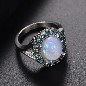 Primer plano de anillo de ópalo ovalado con piedras azules y sello de plata S925