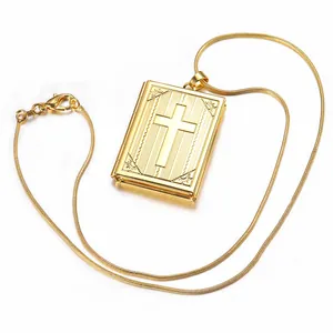 Golden book-shaped locket necklace featuring engraved cross pattern on a snake chain