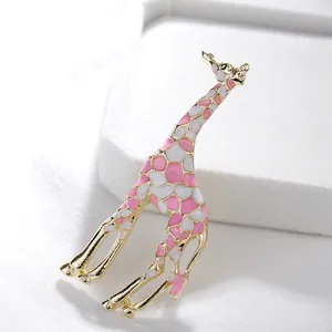 Primer plano de broche de jirafa con esmalte rosa y blanco y detalles dorados
