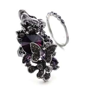 Vintage silver butterfly ring set with a large purple crystal and ornate floral metal carving