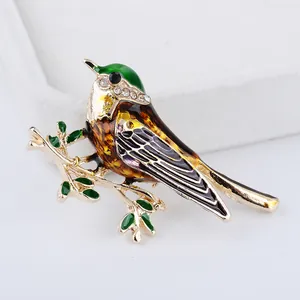 Elegante broche de pájaro dorado con esmalte de colores y brillantes diamantes