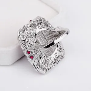 Macro detail of silver filigree ring with vintage red crystals and hollow pattern